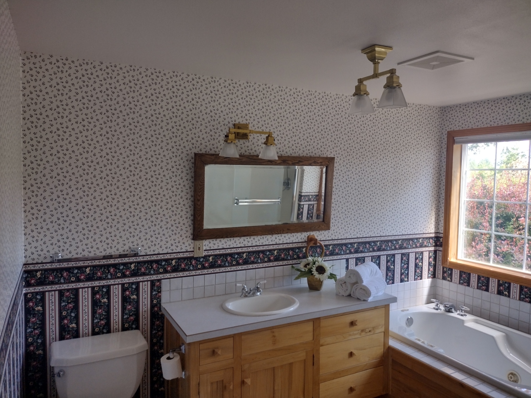 Dated master bathroom with floral wallpaper and built-in tub before Clean Construction LLC remodel